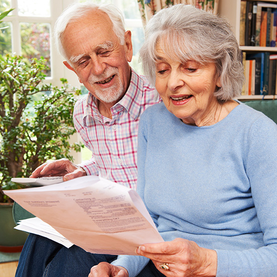Elderly couple reading a newspaper